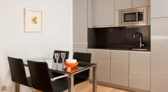 Furnished dining room and equipped kitchen of apartment for rent in Madrid
